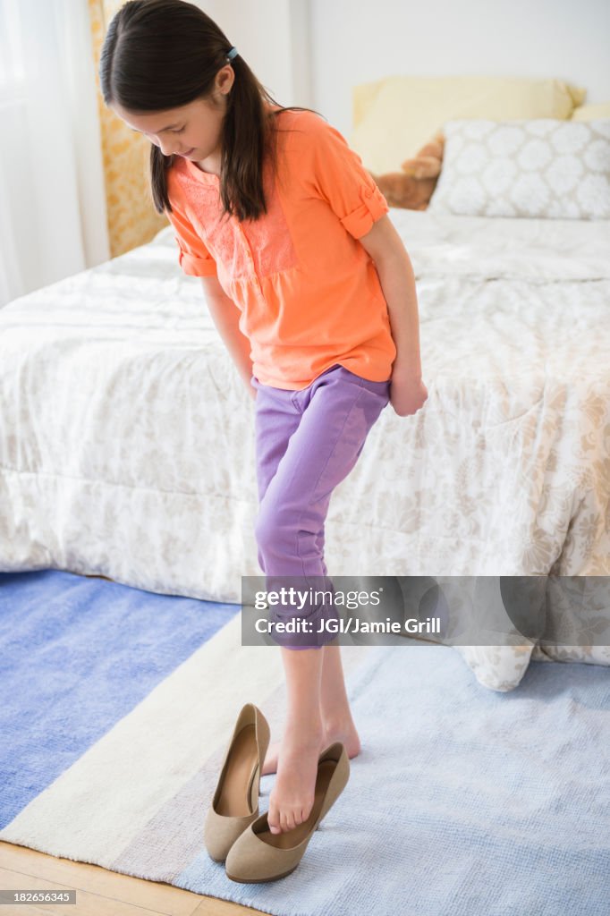 Mixed race girl trying on mother's heels