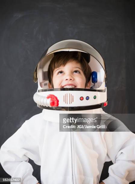 hispanic boy wearing space helmet in classroom - astronaut kid stockfoto's en -beelden