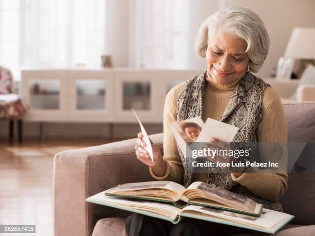 older black woman looking at photographs - females photos stock-fotos und bilder