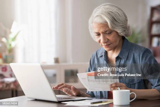 older black woman paying bills on laptop - online bank account stock pictures, royalty-free photos & images