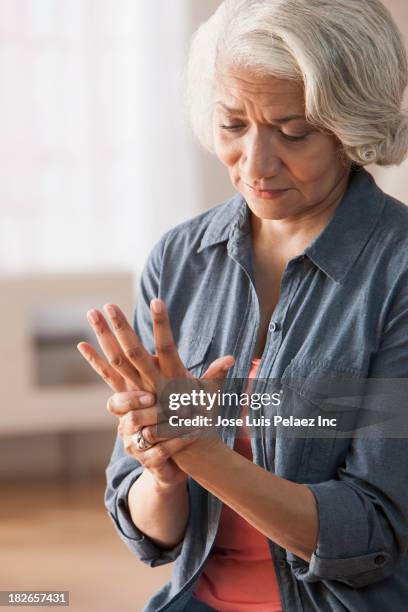 older black woman rubbing her hands - arthritis hands photos et images de collection