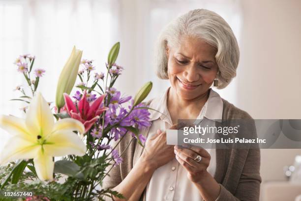 older black woman receiving bouquet of flowers - danke blumen stock-fotos und bilder