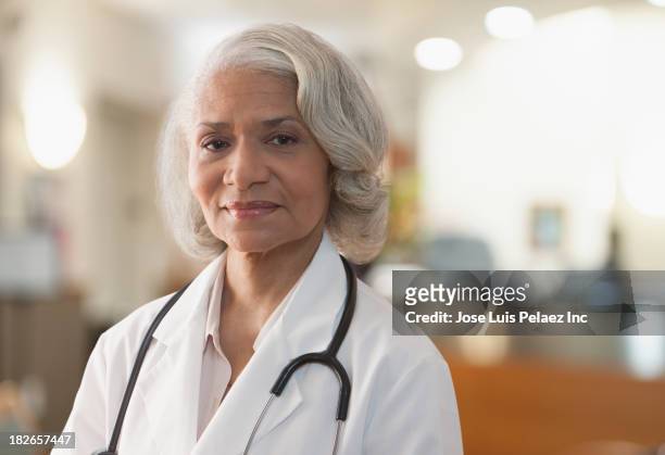 black doctor standing in hospital - black female doctor stock-fotos und bilder