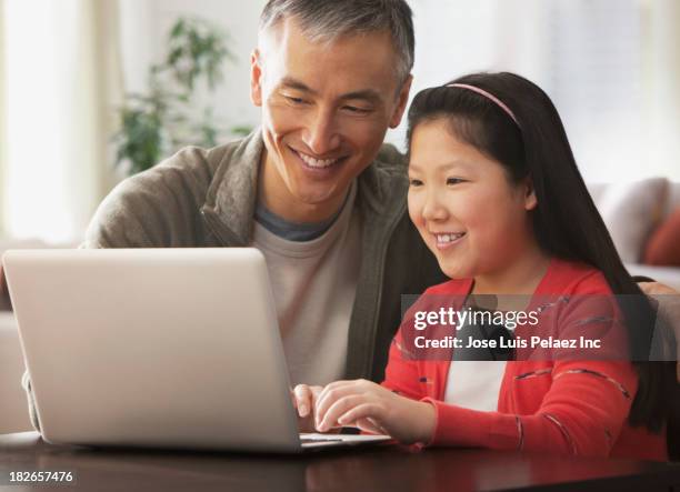 father and daughter using laptop together - japanese people typing stock pictures, royalty-free photos & images