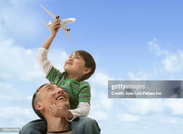 father carrying son on shoulders outdoors - flying dad son stock pictures, royalty-free photos & images