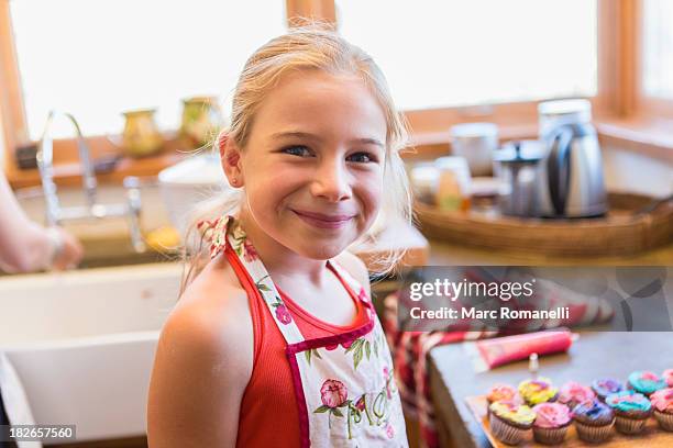 caucasian girl smiling in kitchen - cupcakes girls fotografías e imágenes de stock