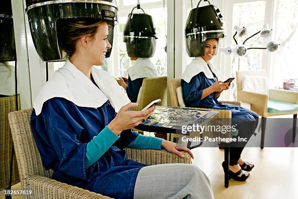 women having hair done in salon - hair dryer foto e immagini stock