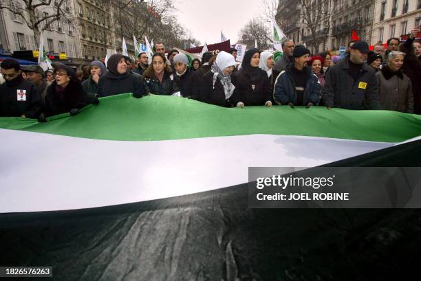 Des personnes défilent avec un drapeau irakien le 18 janvier 2003 à Paris, lors d'une manifestation pour dire "non à la guerre", à l'appel d'une...
