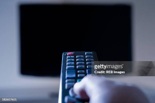 hispanic man using remote control - changing channels stockfoto's en -beelden