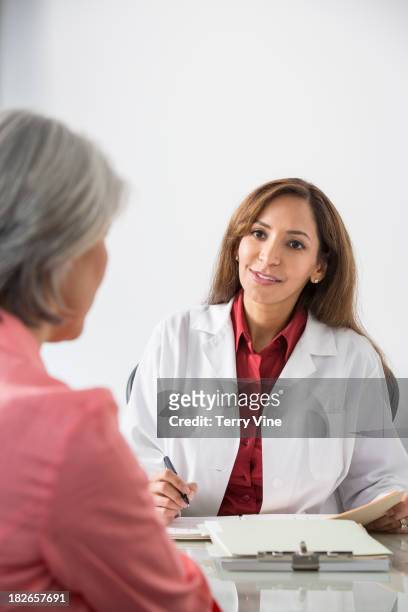 doctor talking with patient in office - patientin stock-fotos und bilder