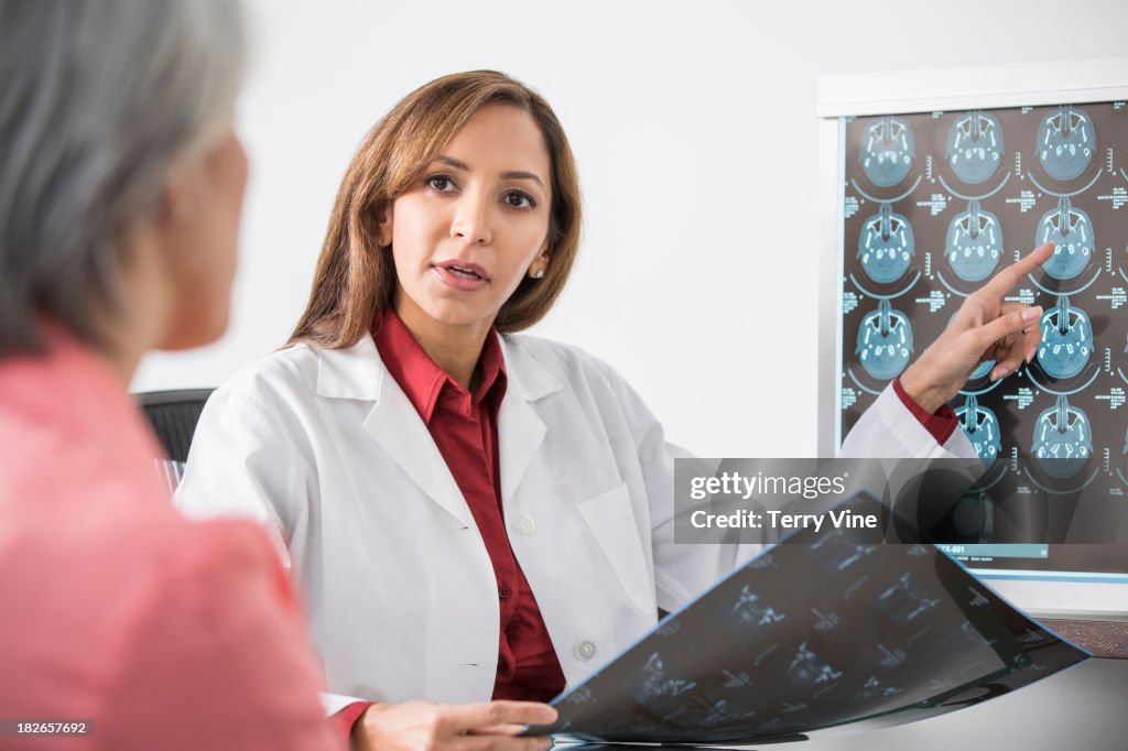 Doctor showing x-rays to patient in office