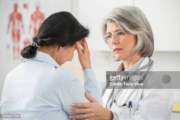doctor examining patient in office - frau sorgen 45 jahre stock-fotos und bilder