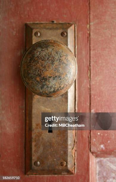 rusty bronze doorknob on a red door - doorknob shock stock pictures, royalty-free photos & images