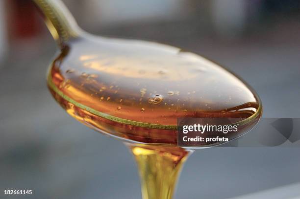 a spoonful of golden syrup overflowing from it - syrup stock pictures, royalty-free photos & images