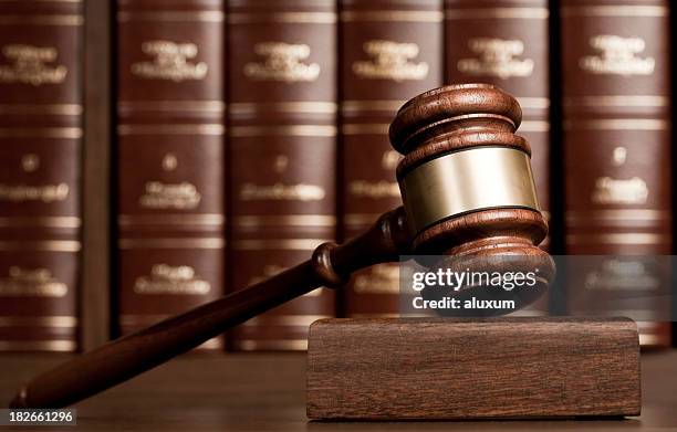 gavel on wooden desk with books as background - voorzittershamer stockfoto's en -beelden