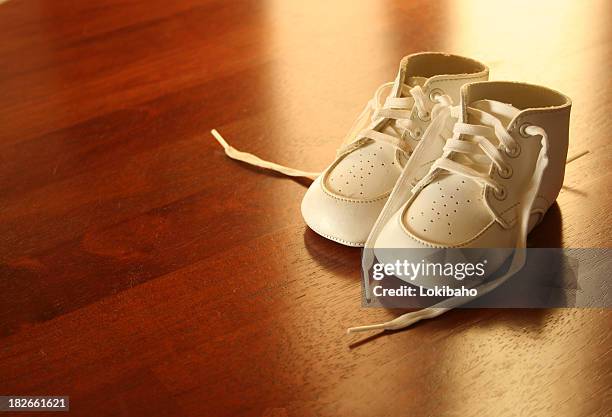 bebê sapatos em luz sobre madeira - baby booties imagens e fotografias de stock