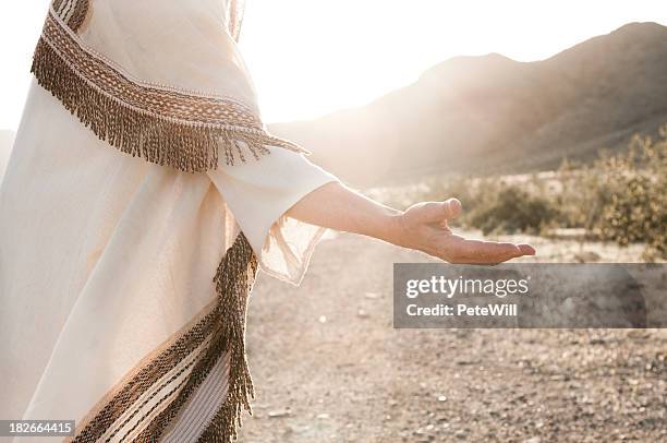 person depicting jesus and reaching hand out - ceremonieel gewaad stockfoto's en -beelden