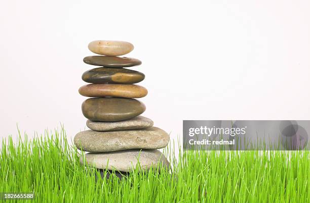 natürliche gleichgewicht - grass pile white background stock-fotos und bilder