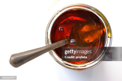 Isolated image of a spoon inside a jar of syrup Isolated image of a spoon inside a jar of syrup