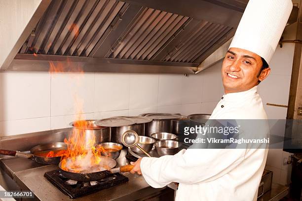 indian chef working cooking in a restaurant kitchen - indian chef stock pictures, royalty-free photos & images