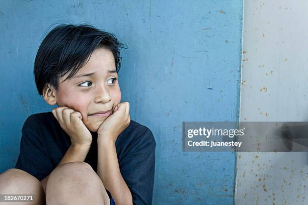 a sad child leaning against a wall - shy stock pictures, royalty-free photos & images