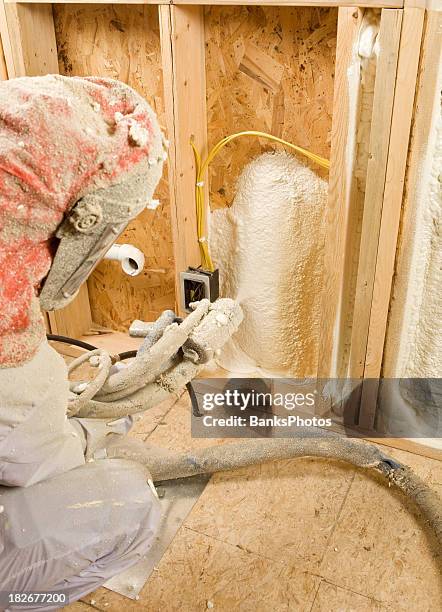 trabajador de la construcción de la pulverización, ampliables espuma aislamiento entre los tornillos de montaje en pared - latex fotografías e imágenes de stock