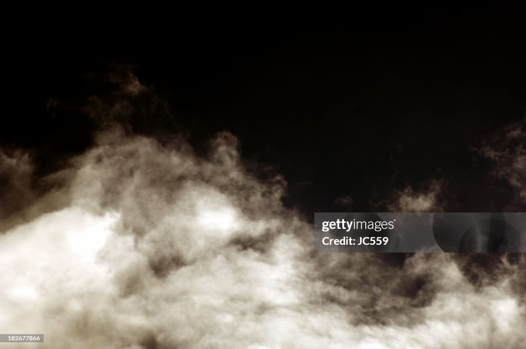 White clouds of smoke on a black background