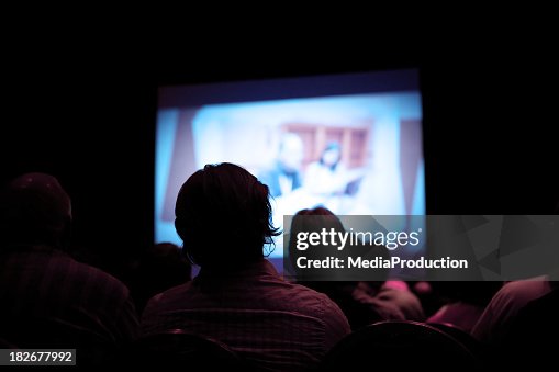People watching movie in dark cinema People watching movie in dark cinema