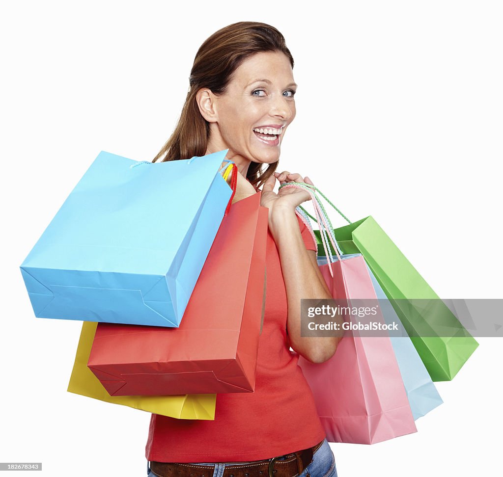 Mujer de mediana edad feliz con bolsas de compras sobre fondo blanco