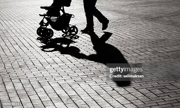 black and white shadow of baby carriage on sidewalk stones - onherkenbaar persoon stockfoto's en -beelden