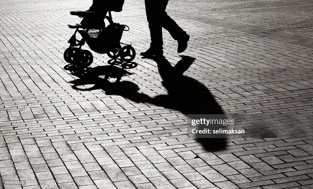 Black And White Shadow Of Baby Carriage On Sidewalk Stones
