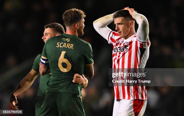 Adam Randell and Dan Scarr of Plymouth Argyle celebrate as Ciaran Clark of Stoke City cuts a dejected figure following the Sky Bet Championship match...