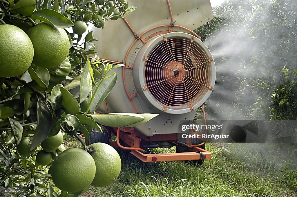 A crop sprayer on some fruit trees