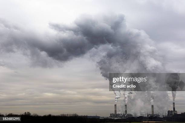 pollution spilling into the sky from a power plant - växthusgas bildbanksfoton och bilder