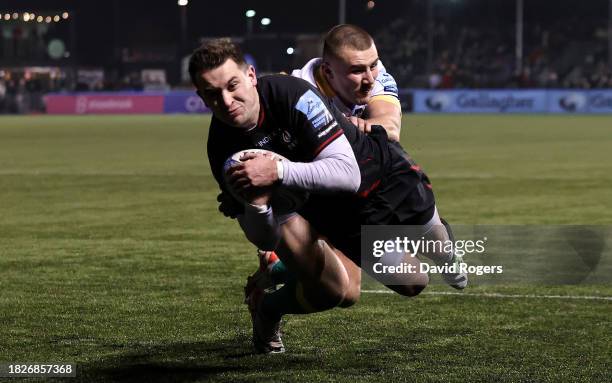 Tom Parton of Saracens dives over for their first try despite being held by Ollie Sleightholme during the Gallagher Premiership Rugby match between...