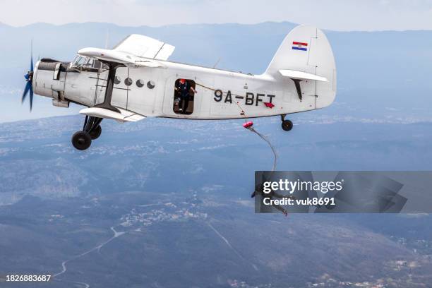 paracaidistas saltan de un viejo biplano militar - adrenalina fotografías e imágenes de stock