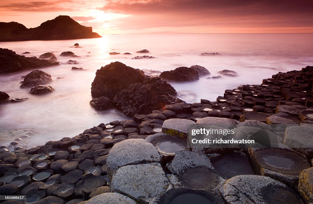 A Giants Causeway with fog on the ground during sunrise
