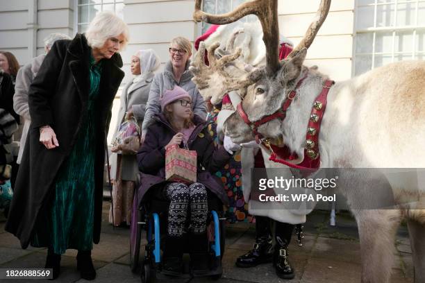 Britain's Queen Camilla looks at a reindeer after she invited children, supported by Helen & Douglas House and Roald Dahl's Marvellous Children's...