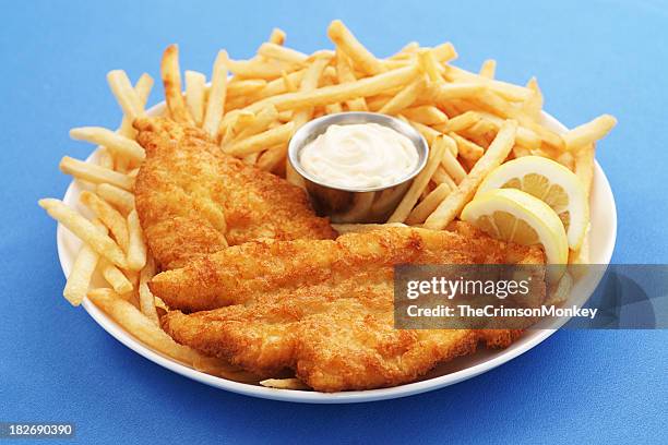 a close up of a fish and chips platter with dipping sauce - seafood platter stockfoto's en -beelden