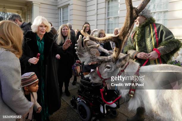 Britain's Queen Camilla greets a reindeer after she invited children, supported by Helen & Douglas House and Roald Dahl's Marvellous Children's...
