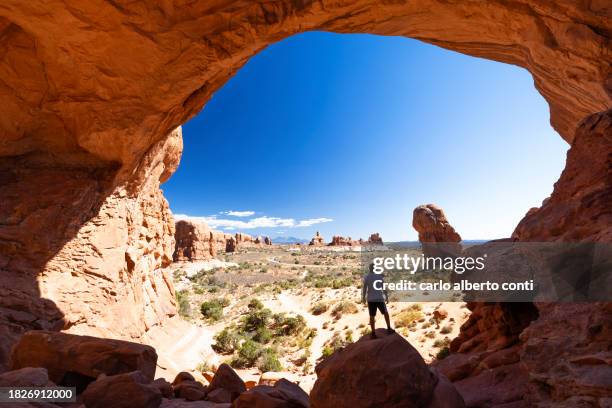 a boy enjoy the beautiful landscape in arches national park during a summer sunny day, utah, united states of america - rock formation stock pictures, royalty-free photos & images