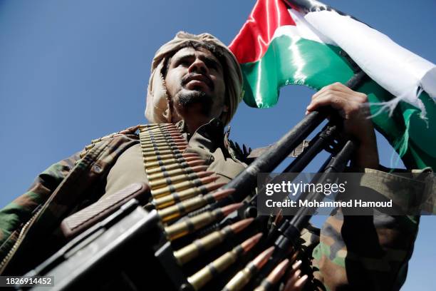 Yemenis recently militarily trained by the Houthi movement hold their guns as they take part in an armed popular parade held in Al-Sabeen Square to...