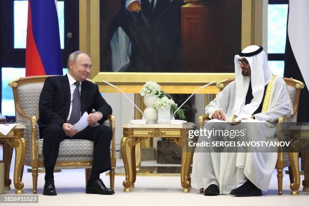 This pool photograph distributed by Russian state agency Sputnik shows Russia's President Vladimir Putin and President of the United Arab Emirates...