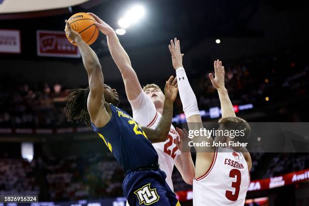 Steven Crowl of the Wisconsin Badgers blocks the shot of Sean Jones of the Marquette Golden Eagles in the first half of the game at Kohl Center on...