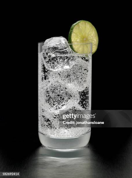 gin tonic cóctel sobre fondo negro - agua carbonatada fotografías e imágenes de stock