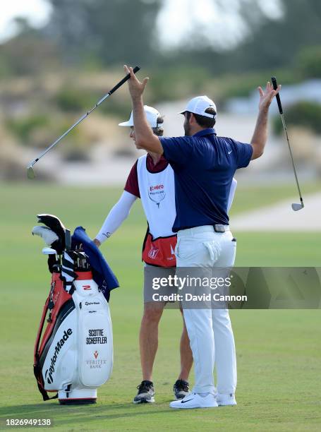 Scottie Scheffler of the United States waves his clubs at his playing partner Jordan Spieth who was deep in teh bushes off the tee as he waits to...