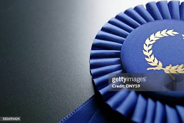 blue ribbon rosette on dark gray graduated background - award winner stockfoto's en -beelden