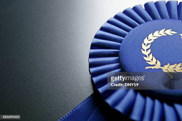 blue ribbon rosette on dark gray graduated background - winning stock pictures, royalty-free photos & images