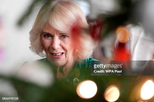 Britain's Queen Camilla looks at the Christmas tree after invited children, supported by Helen & Douglas House and Roald Dahl's Marvellous Children's...