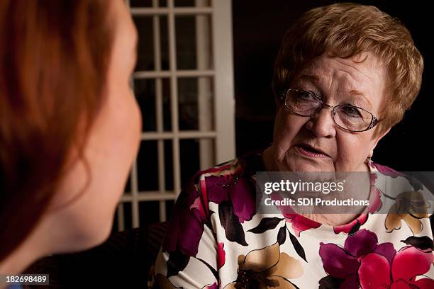 concerned senior adult having serious conversation with young woman - young woman with grandmother stock pictures, royalty-free photos & images